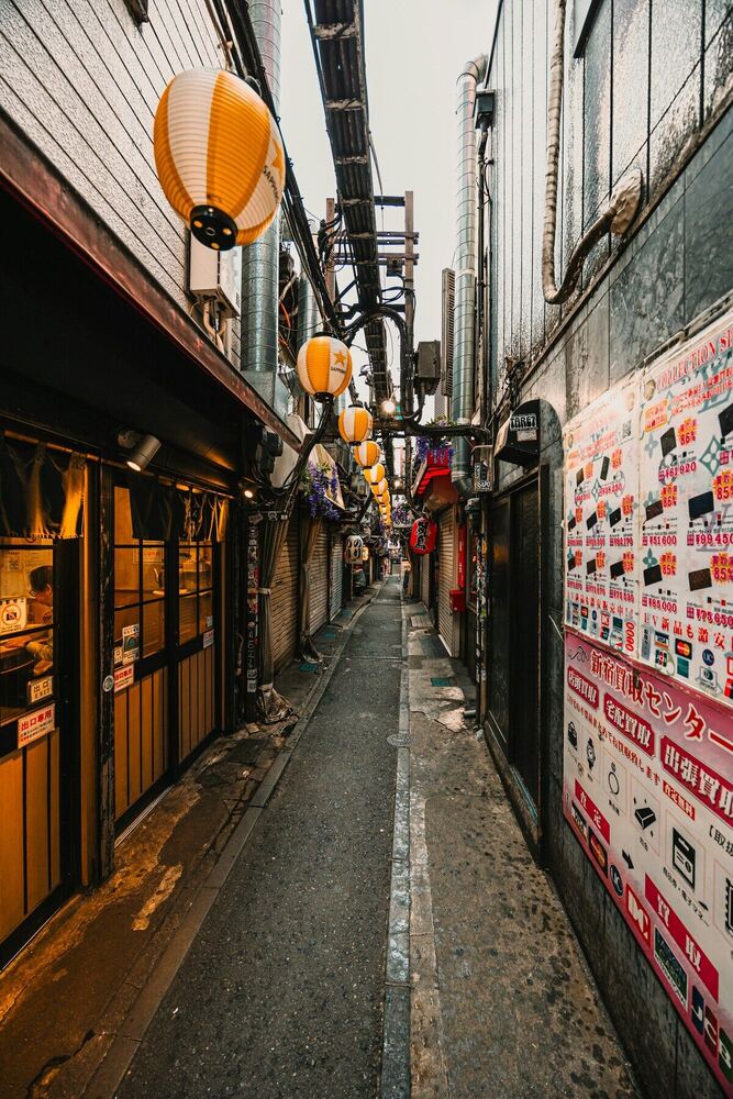 東京の路地裏。提灯が灯る夕暮れの小道